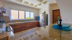 A modern kitchen with a large window, granite countertops, and a built-in oven.