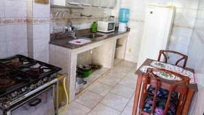 Een keuken met een gasfornuis, spoelbak, magnetron en waterdispenser.