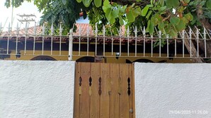 Een poort met een houten hek en een witte muur.