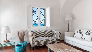 A living room with a sofa, a coffee table, a lamp, and two potted plants. - Villa 'Casa 14' with Sea View, Private Terrace and Air Conditioning (Castiadas)