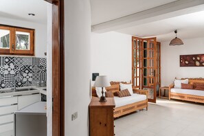 Una habitación con cama, un armario de madera, una lámpara, un sofá y salpicadero de azulejos.