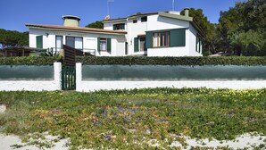 A modern two-story house with a white exterior and green shutters, a visible satellite dish, and a paved driveway. - Villa 'Massidda' with Sea View, Wi-Fi, and Air Conditioning (S.Margherita di Pula)