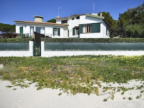 A modern two-story house with a white exterior and green shutters, a visible satellite dish, and a paved driveway. - Villa 'Massidda' with Sea View, Wi-Fi and Air Conditioning (S.Margherita di Pula)