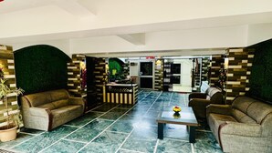 A spacious lobby with a reception desk, two sofas, a coffee table, and a patterned floor.