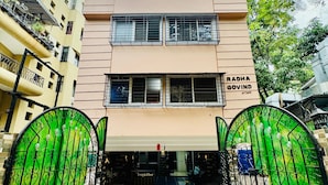A two-story building with a sign reading "RADA GOVIND" and a gated entrance.