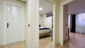A hotel room with a bed, a door, and a view of another room. - One-Bedroom Apartment in Taksim - No: 5 (Istanbul)