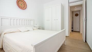 Ein Schlafzimmer mit einem Bett, einem Kleiderschrank, einem Nachttisch und einem Wanddekor.