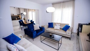 Una sala moderna con sofá, mesa de centro y comedor con sillas.