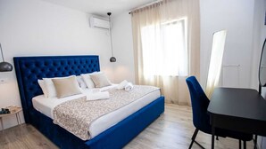 Un dormitorio con una cama grande, un escritorio y una silla.