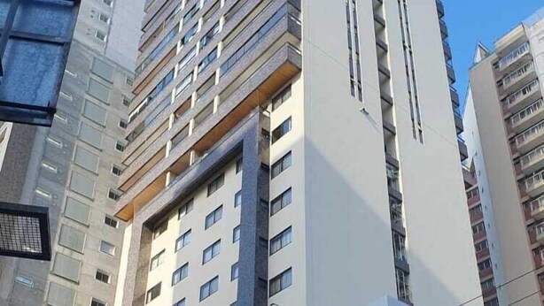 Ein mehrstöckiges Gebäude mit modernem architektonischen Design, das Glas- und Betonelemente kombiniert.