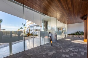 A modern building with large glass windows, a wooden ceiling, and a paved outdoor area with a bench. - Ref. 507196 (Motril)