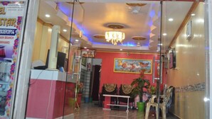The entrance of Hotel Dream Star with a red facade, a glass door, and a chandelier inside. - Hotel Dream Star  (Sahibganj)