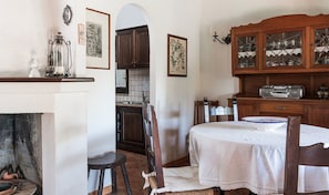 A traditional room with a fireplace, wooden furniture, and a dining area.