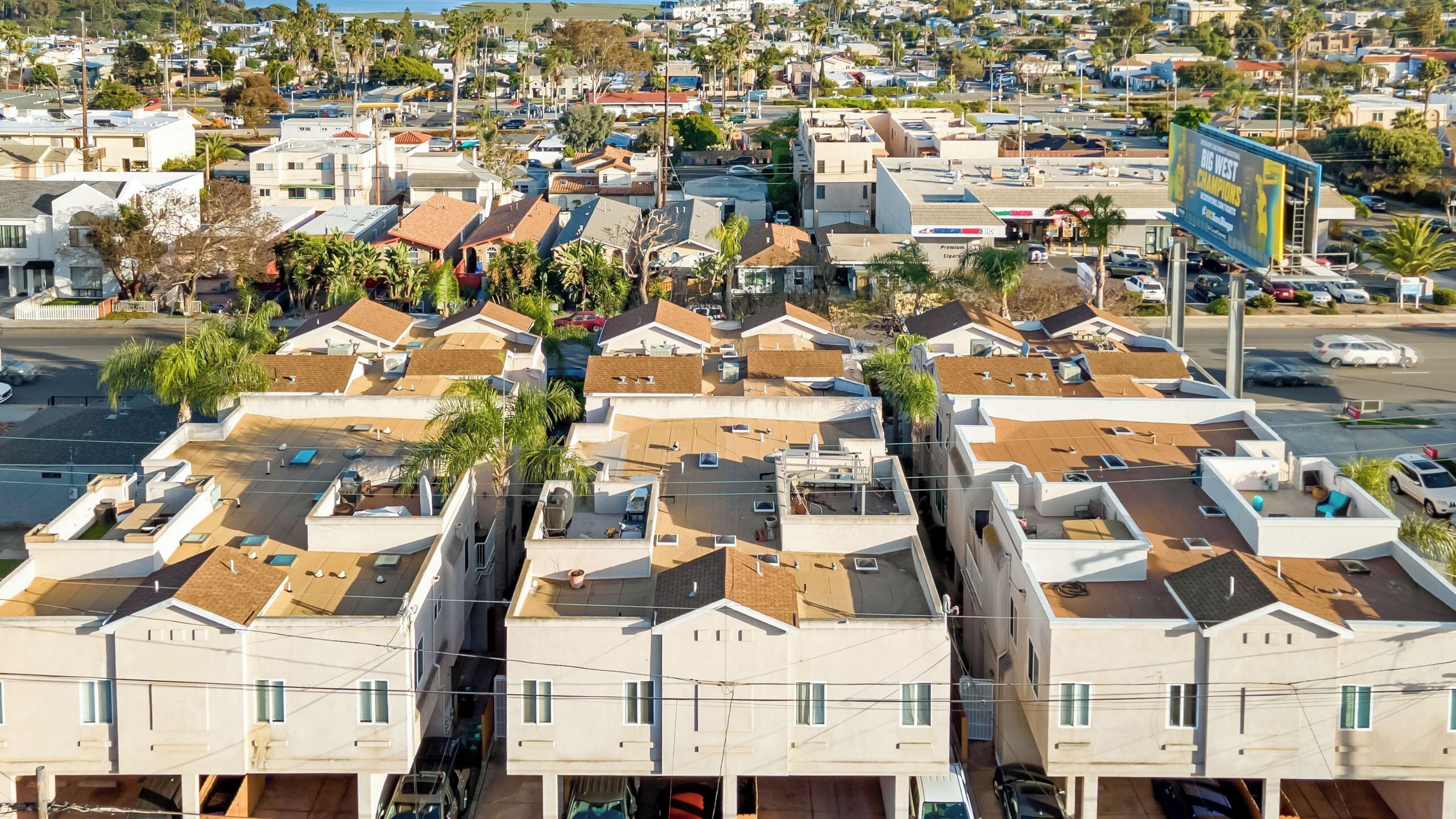 A residential area with multiple two-story houses, each with a flat roof and a small balcony.