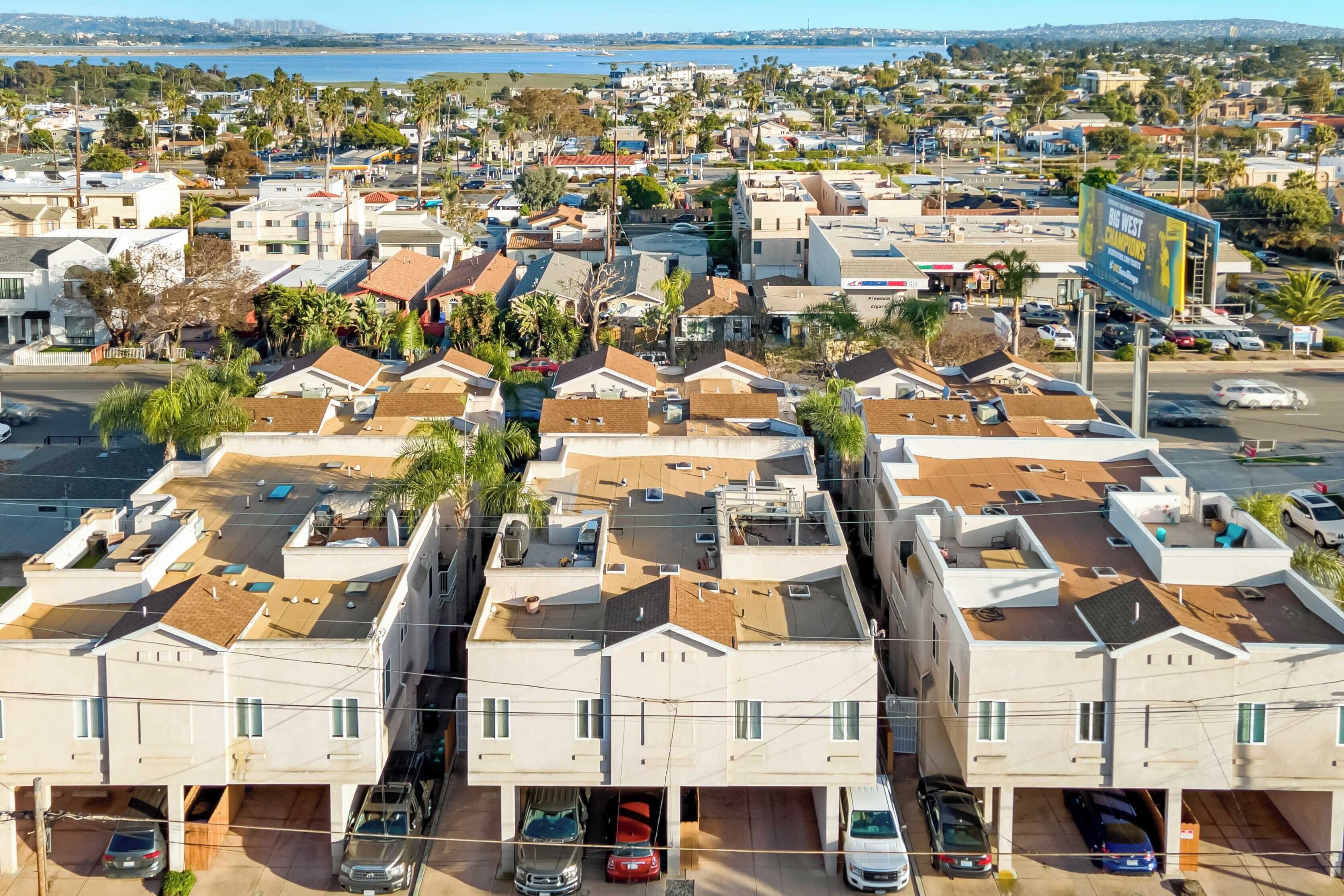 Un quartier résidentiel composé de plusieurs maisons à deux étages, chacune ayant un garage et une place de stationnement.