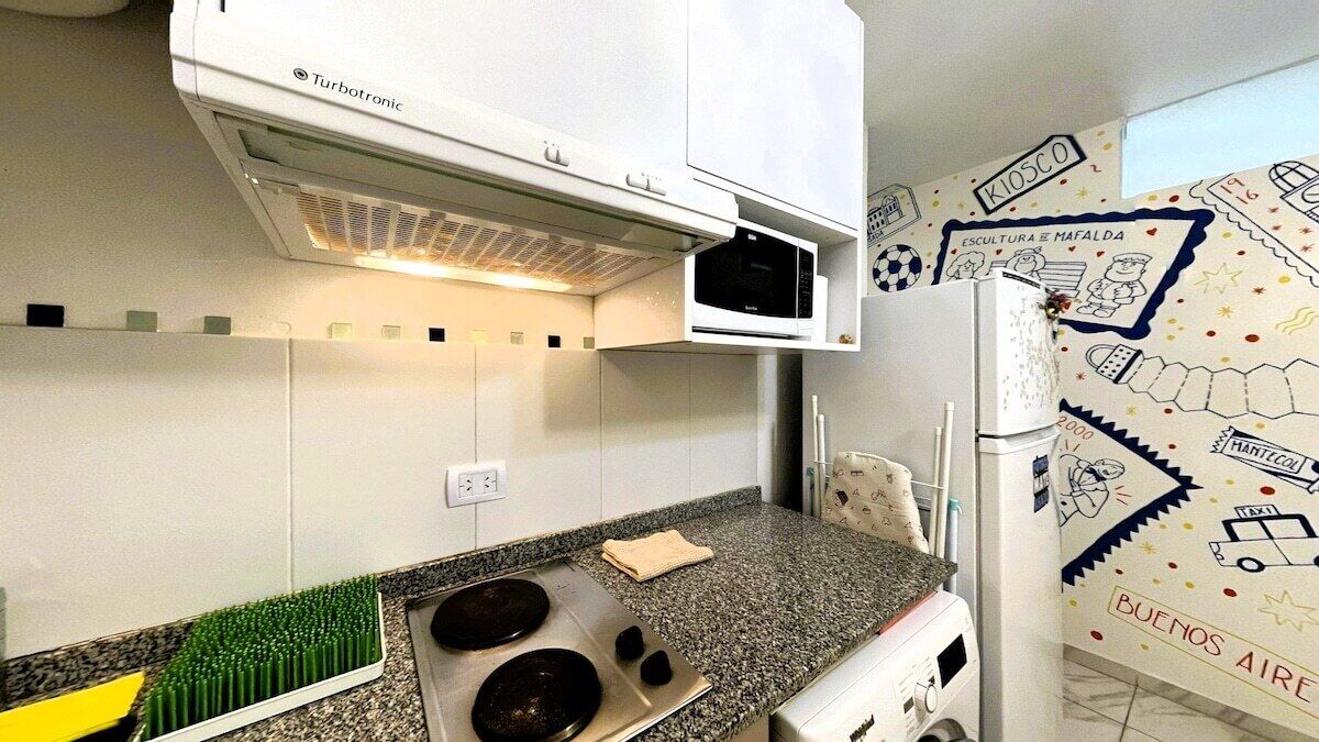 Una cocina con estufa integrada, microondas y horno empotrado.
