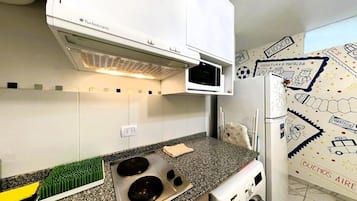 Una cocina con estufa integrada, microondas y horno empotrado.