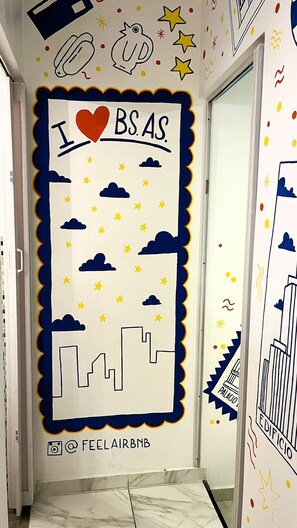 A hallway with a wall mural featuring a city skyline, stars, and clouds. - Experience Buenos Aires · Central & Artistic (Buenos Aires)