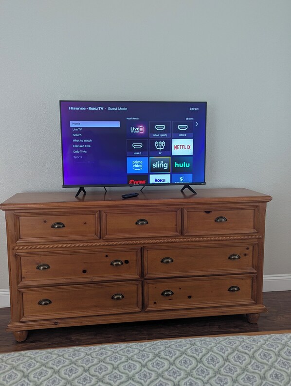 A television on a wooden dresser with a Roku interface. - The Garden House - 3BR /6 Guests (Lutz)
