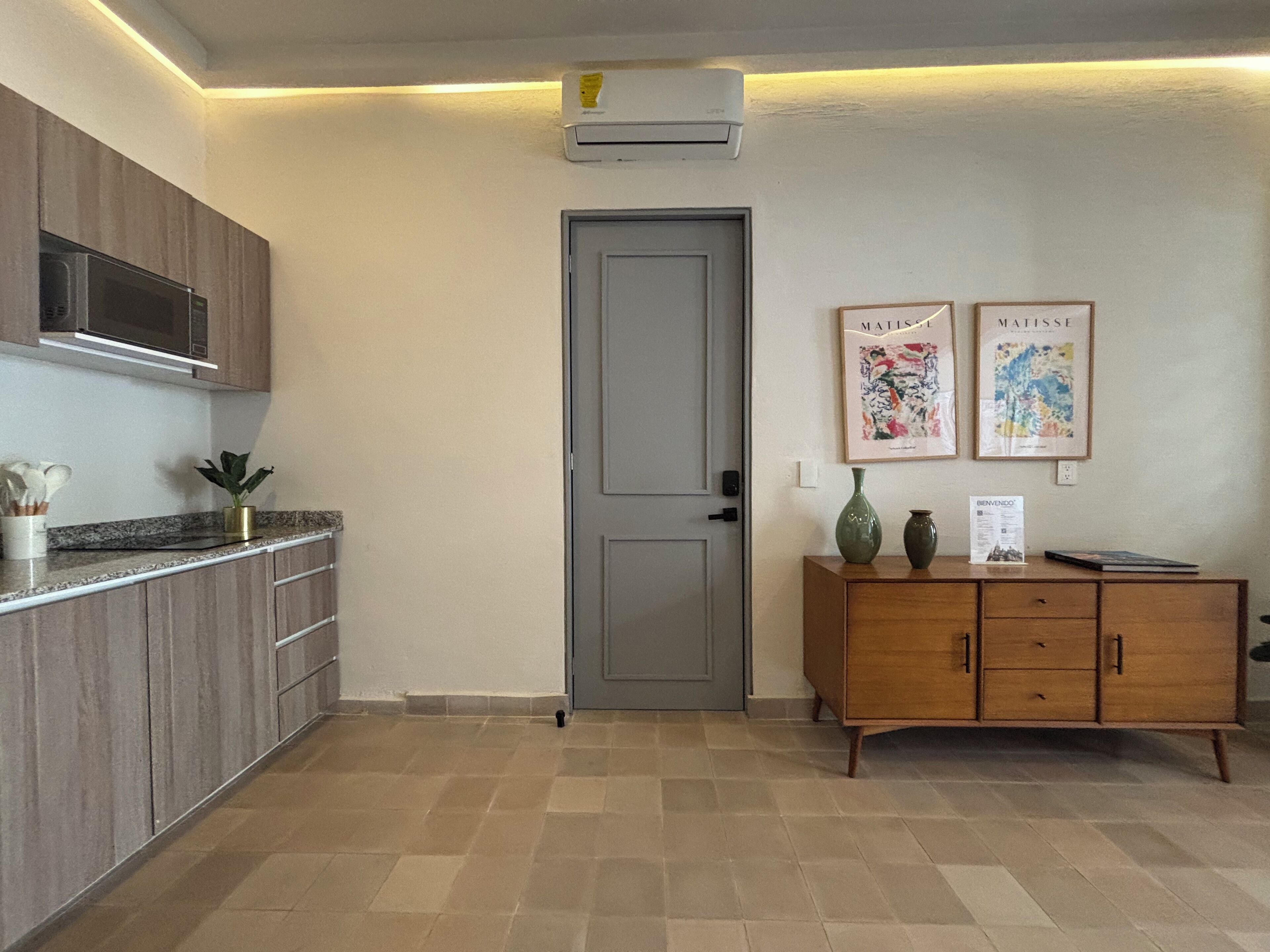 A kitchen with wooden cabinets, a microwave, and a tiled floor.