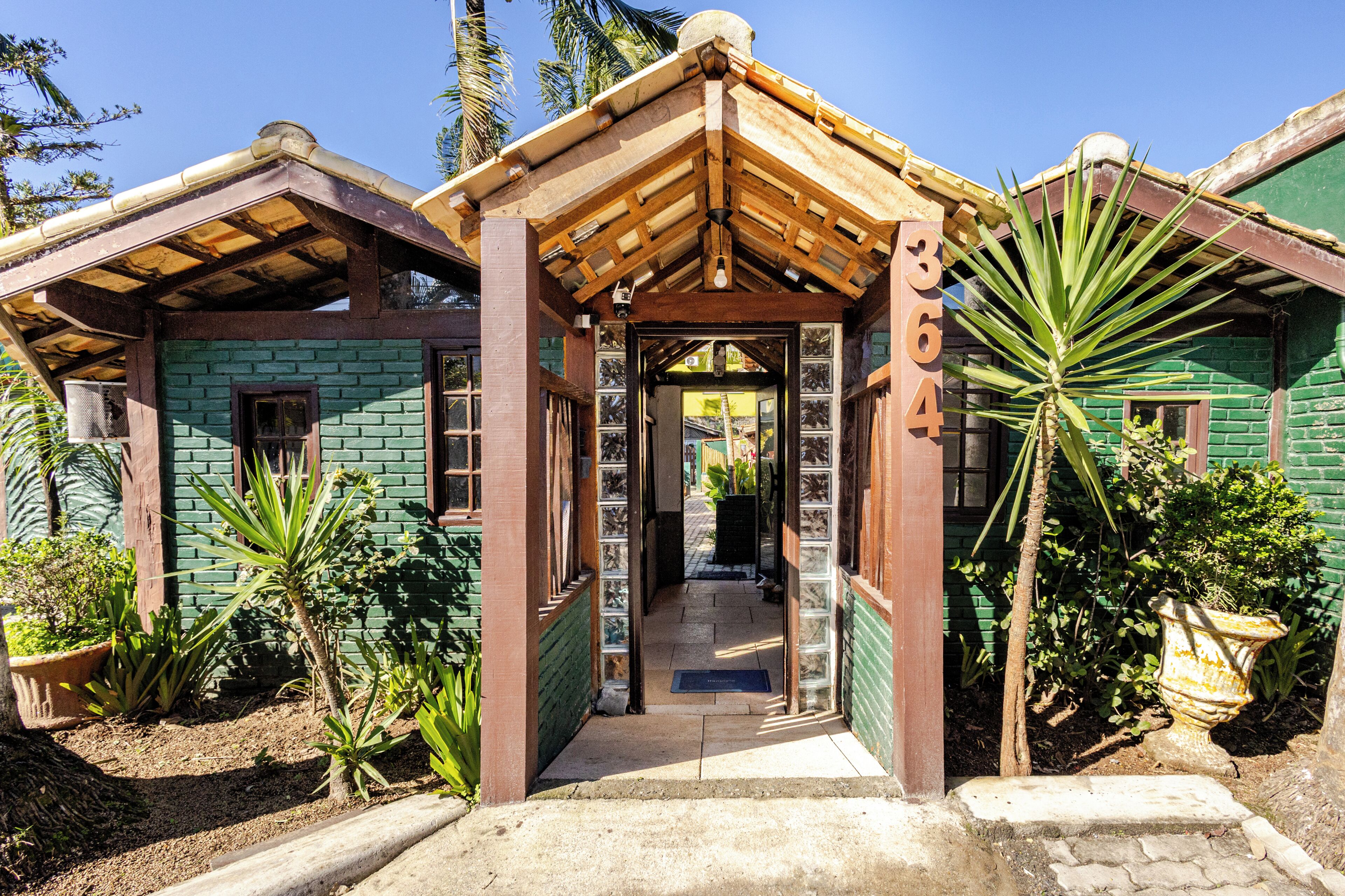 A traditional house with a wooden porch, brick walls, and a clear sky.