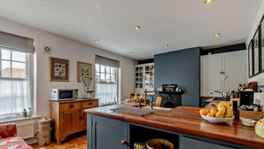 Una cocina moderna con una isla central, armarios de madera y un microondas.