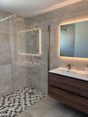 Een douche, een haardroger, handdoeken, toiletpapier