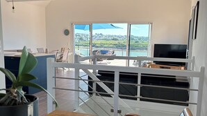 Une cuisine moderne dotée d’une grande fenêtre donnant sur un lac et des collines.