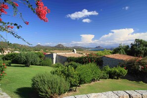 Paisatge rural amb edificis de pedra, cel serè i muntanyes llunyanes.