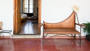 A spacious room with a wooden ceiling, a leather sofa, and a hanging light fixture. - CASA MADERO (Tapalpa)
