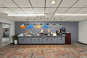 A modern kitchen with grey cabinets, a central island, and overhead lighting. - Quality Inn & Suites Caribou (Caribou)