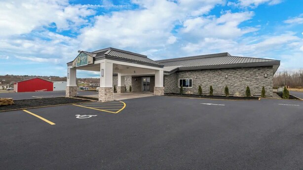 A building with a stone facade, a covered entrance, and a handicap parking space. - Quality Inn & Suites Caribou (Caribou)
