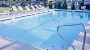 A swimming pool with lounge chairs and a lifebuoy.
