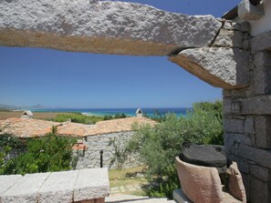 Ein Steinhaus mit Blick auf das Meer und ferne Berge.