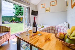 Enjoy a romantic dinner for two in this inviting room, complete with a wine table setting and a view of the lush garden.