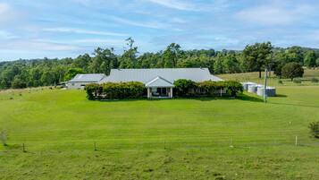 A large, single-story building with a flat roof, surrounded by a well-maintained grassy field.