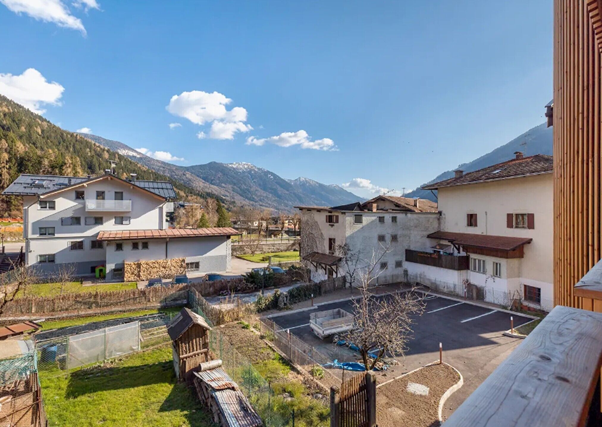 Zona residencial con casas, un estacionamiento y montañas al fondo.