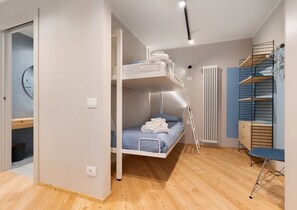 A room with a bunk bed, a desk with a chair, a radiator, and a wall with shelves. - Apartment 'Palazzo Righi - Blu' with Mountain View, Balcony and Wi-Fi (Carisolo)