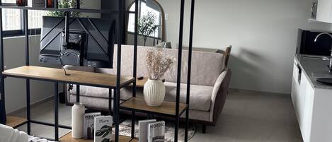 A modern living room with a wooden coffee table, a sofa, and a TV.