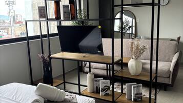 Ein modernes Schlafzimmer mit Bett, Schreibtisch und einer Couch.