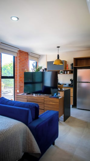 A modern kitchen with a built-in oven, a refrigerator, and a dining area with a table and chairs.