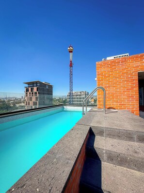 A rooftop pool with a clear view of the cityscape, including a tall communication tower and modern buildings. - Modern stay in Colonia Americana (Guadalajara)