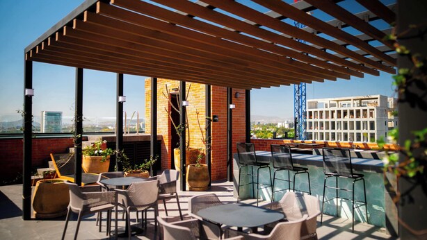 A rooftop terrace with outdoor seating, potted plants, and a view of the cityscape. - Modern stay in Colonia Americana (Guadalajara)