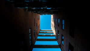 A narrow alleyway with brick walls and a clear blue sky visible through the gaps. - Modern stay in Colonia Americana (Guadalajara)