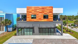 A modern building with a wooden facade, large glass doors, and a flat roof.