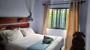 A hotel room with a bed, a window with curtains, an air conditioning unit, and a decorative headboard. - Stylish Home w/Private Pool, AC and Free Starlink High-speed Wi-Fi (Lusaka)