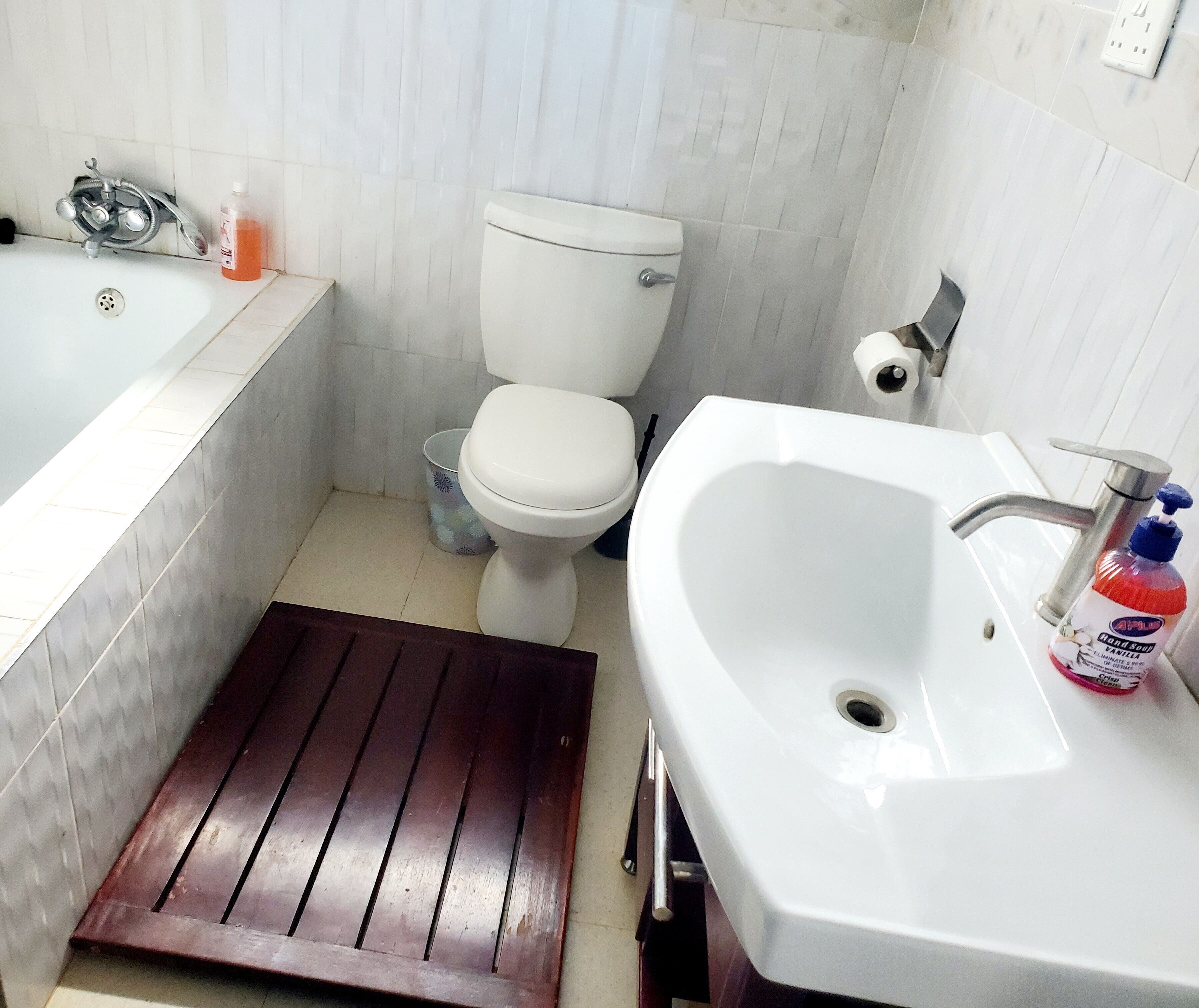 Un baño con lavamanos blanco, inodoro y bañera.