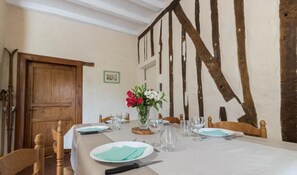 A dining table set with plates, cutlery, and a vase of flowers. - Le Baruch - Montgaillard-sur-Save (Montgaillard-sur-Save)