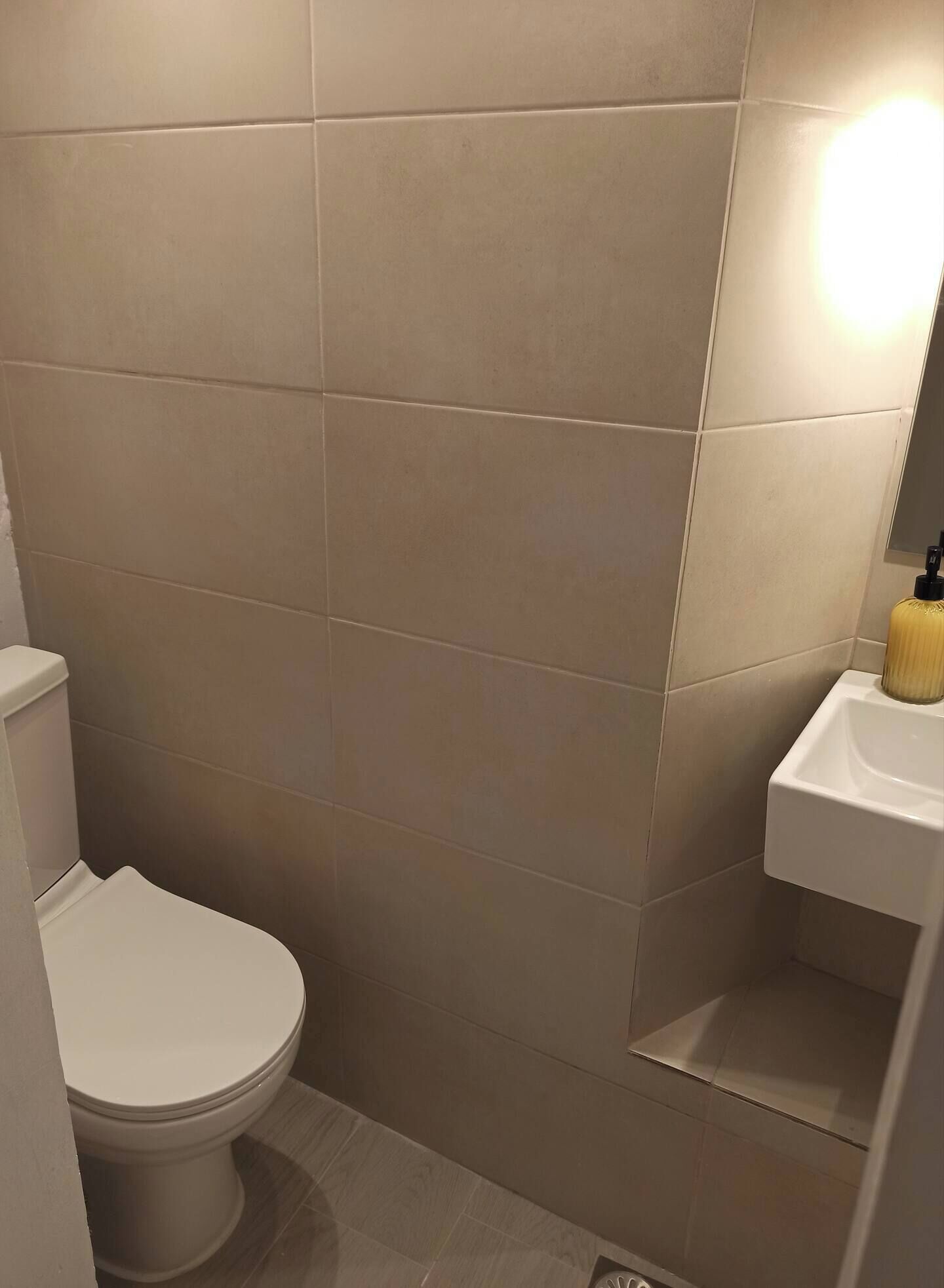 Ein Badezimmer mit Toilette, Waschbecken und Spiegel.