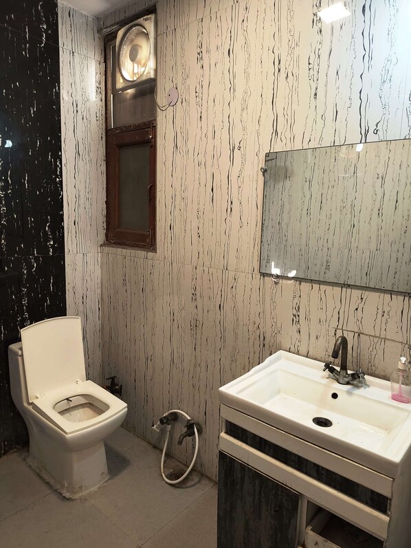 Un baño con inodoro, lavabo y espejo.